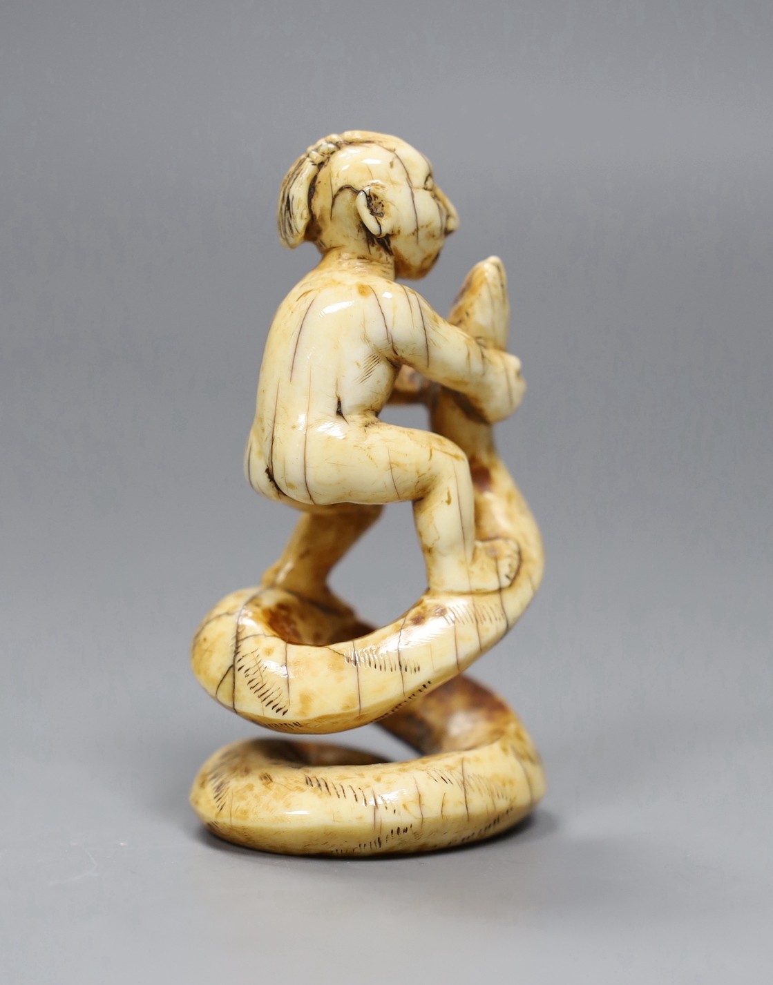 A 19th century native American marine ivory group of a warrior wrestling a snake, 7cm high